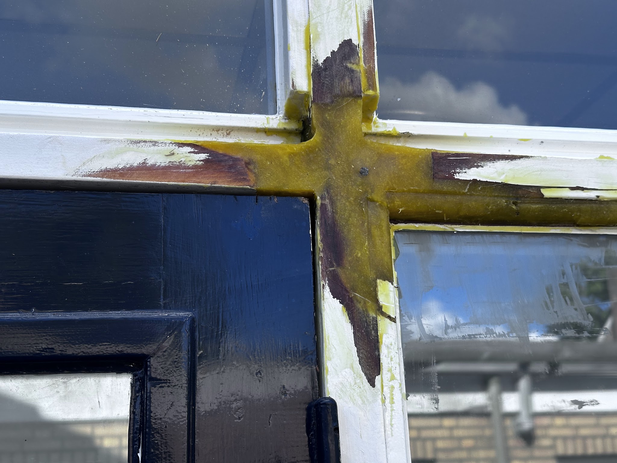 Detail van plamuur- en kitwerk op de hoek van een raamkozijn